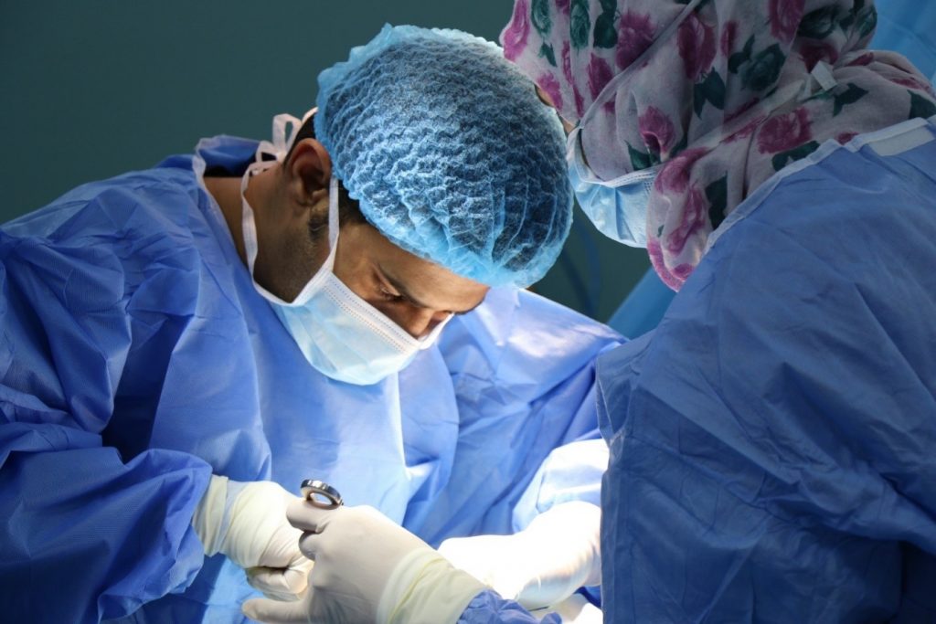 A surgeon bent over a patient in the OR